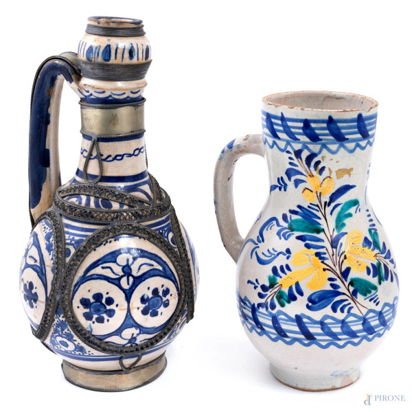 Lotto di due versatoi in maiolica decorata nei toni del bianco e del blu, XX secolo, altezza massima cm 24,5, (segni di usura, sbeccature, cadute di smalto, difetti)