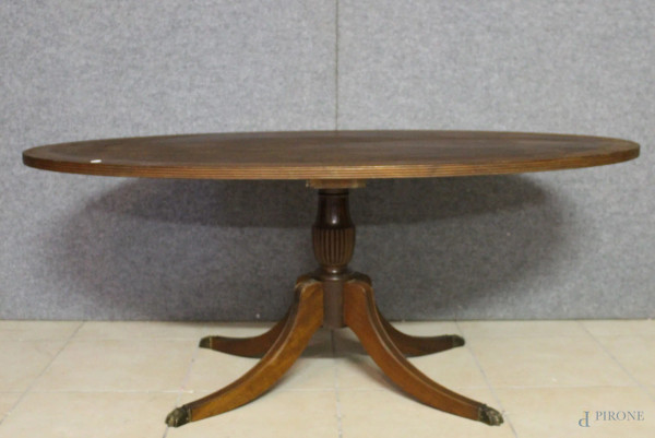 Basso tavolo da salotto di linea ovale in noce e radica poggiante su quattro gambe con inserti in bronzo a zampa di felino, h.53xdiam.130 cm.