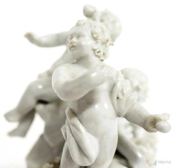 Gruppo in porcellana bianca con finiture dorate raffigurante tre putti che raccolgono le uova, ve...