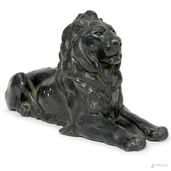 Scultura in metallo patinato raffigurante un leone accosciato, XX secolo, cm 13x25