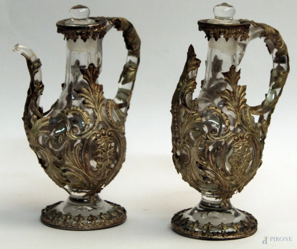Coppia di ampolle in vetro, rivestite in metallo argentato e cesellato, H. 15 cm. XIX sec., (difetti)