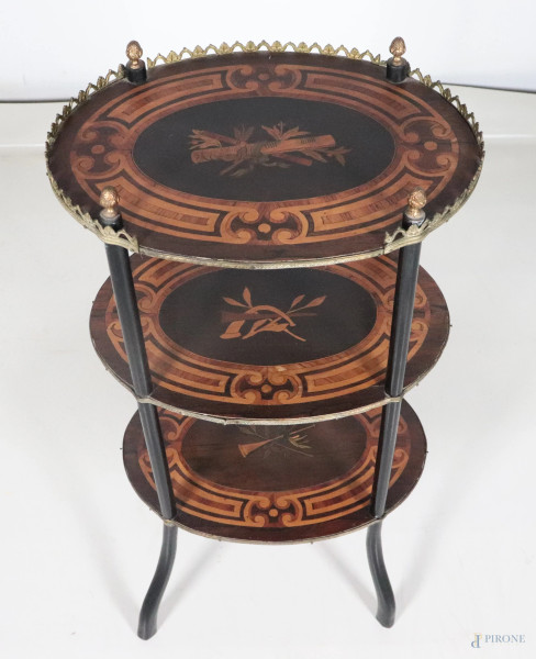 Gueridon stile Napoleone III in mogano e legno ebanizzato con tre piani ovali decorati a pirografo a motivi di strumenti musicali, XX secolo, cm 78x41x30, (segni di usura, scalfiture, difetti)