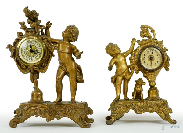 Lotto di due orologi da tavolo in metallo dorato con putti,  alt. max cm 26,5,  prima metà XX secolo, (segni del tempo, meccanismi da revisionare).