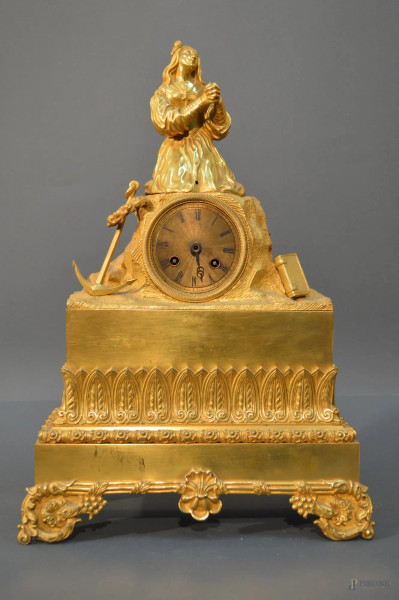 Orologio dell&#39;800 francese in bronzo cesellato e dorato sormontato da figura a rilievo, laterali con ancora, libro e corona d&#39;alloro, h. 46x32x12 cm.
