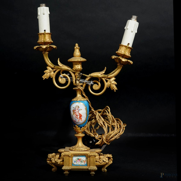 Candelabro a due fiamme in bronzo dorato e porcellana policroma, XIX-XX secolo, trasformato a lampada, cm h 38,5, (difetti, parte rotta)