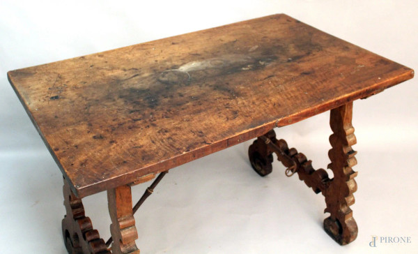 Tavolo fratino in noce, poggiante su due gambe intagliate, legate da crociata in ferro battuto, inizi XVII sec., H. 80x116x68 cm.