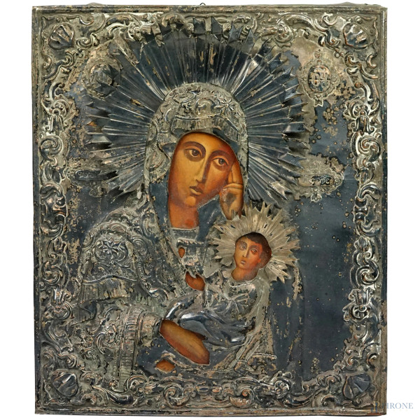 Icona raffigurante Madonna con Bambino, tempera su tavola rivestita in riza in metallo argentato, cm 31,5x27, XX secolo, (segni del tempo).