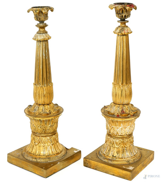 Coppia di candelieri in bronzo dorato con corpo scanalato e cesellato a motivi vegetali, XX secolo, altezza cm 32, (difetti)