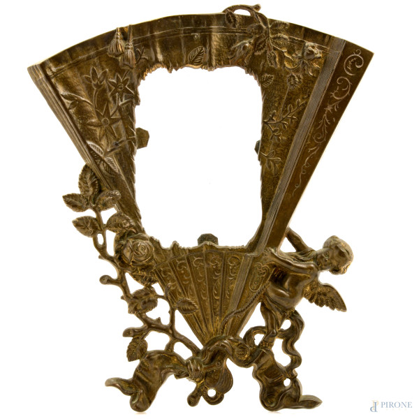 Cornice in stile Liberty in bronzo cesellato a foggia di ventaglio con putto ed elementi floreali, XX secolo, cm 31x26; luce cm 13,5x9, (segni di usura, difetti)