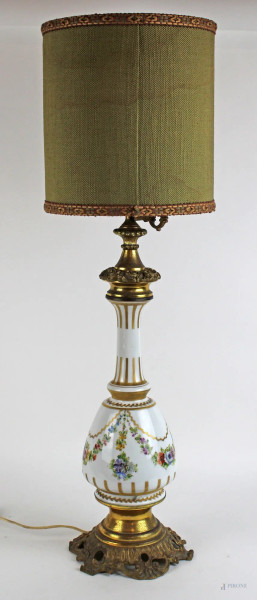 Lampada da tavolo in porcellana bianca, decori policromi a fiori e festoni, base e finiture in metallo dorato, altezza cm. 75, XX secolo.