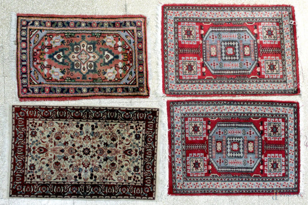 Lotto composto da quattro tappeti scendiletto, misura massima 96x66 cm.