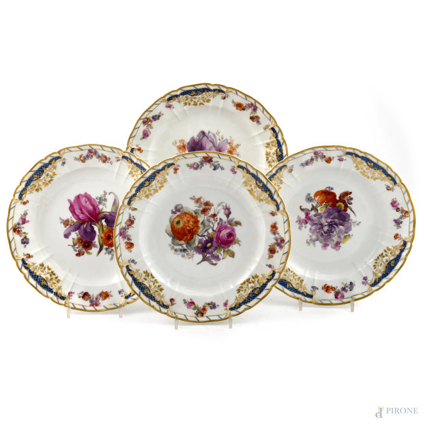 Lotto di quattro piatti in porcellana KPM decorati a motivi floreali con profili dorati, XX secolo, diametro cm 25, (segni di usura, scalfiture, difetti)
