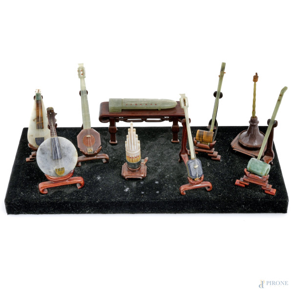 Composizione di 10 strumenti musicali in giada e pietre dure, Cina, XX secolo, cm12x32x14 (rotture, restauri)