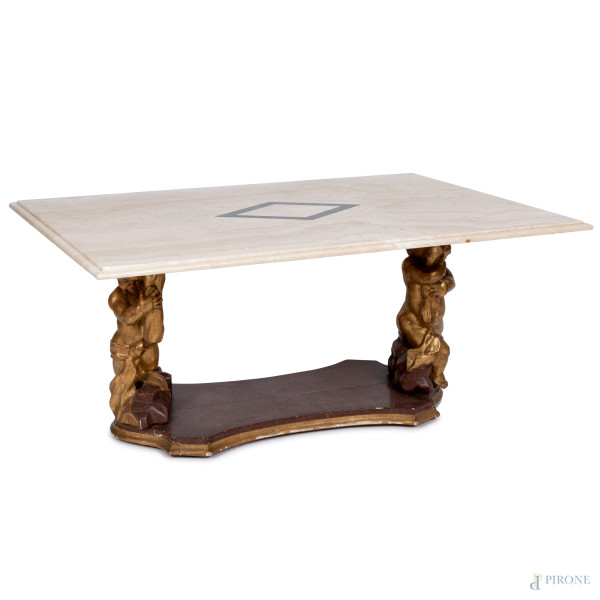 Tavolino basso con piano in marmo sorretto da sculture di putti in legno dorato su pedana sagomata, XX secolo, cm 55x120x80, (segni di usura, piccole scalfiture  del piano, segni di usura, scalfiture, restauri della struttura lignea)