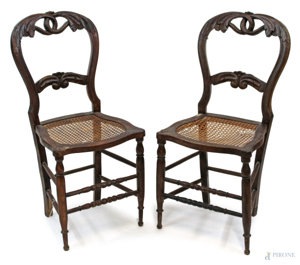 Coppia di sedie in noce, fine XIX secolo, schienali a giorno con cartella di linea sagomata, seduta in canneté, gambe tornite, cm h 88, (difetti).