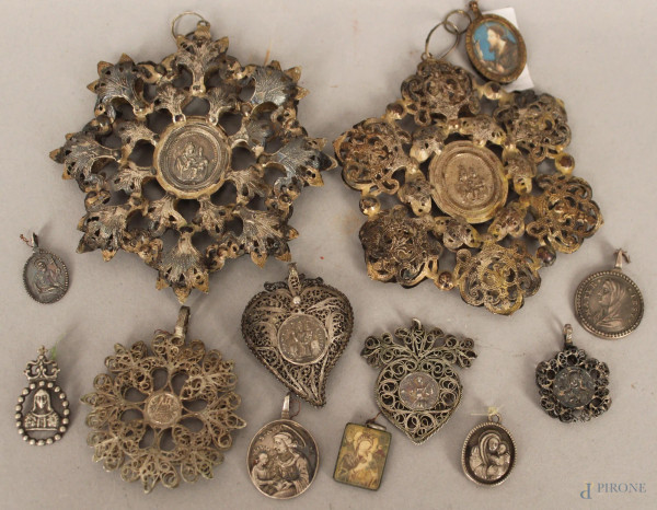 Lotto composto da tredici medaglie in materiali ed epoche diverse a soggetto religioso, altezza max. 11 cm.