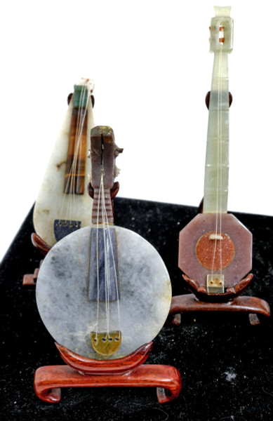 Composizione di 10 strumenti musicali in giada e pietre dure, Cina, XX secolo, cm12x32x14 (rottur...