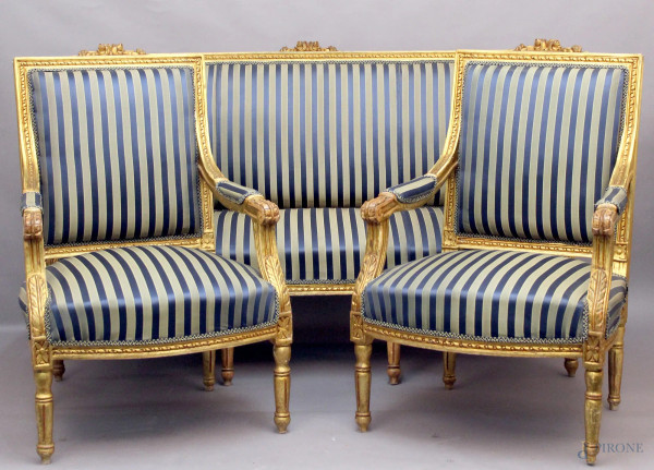 Salotto di linea Luigi XVI composto da un divano e due poltrone in legno dorato ed intagliato.