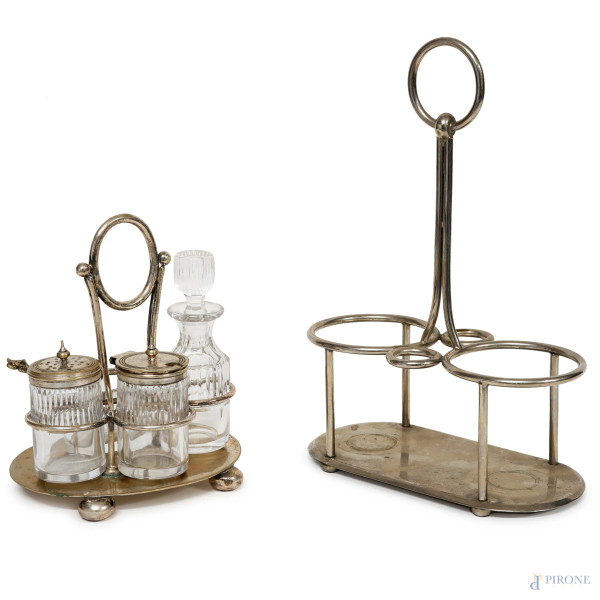 Due oliere in metallo argentato con ampolle e vaschette in vetro, manifatture diverse, altezza max cm 25, (difetti e mancanze)