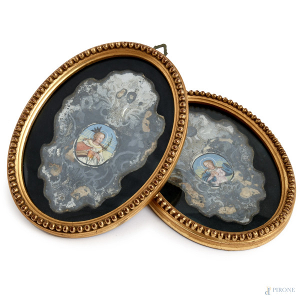 Coppia di piccoli dipinti su specchio al mercurio entro cornici ovali, XX secolo, misure complessive cm 19x14,5, (difetti, mancanze)
