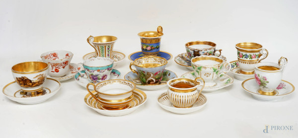Collezione di 12 tazzine da tè in porcellana policroma, diverse manifatture del XIX-XX secolo, con decorazioni variopinte a motivi floreali, alt. max cm 10,5, (difetti)