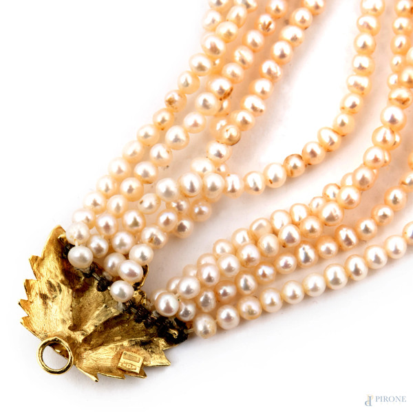 Collana a 9 fili di perle con chiusura in oro 18 kt. Ciondolo in oro 18 kt e centrale in corallo,...