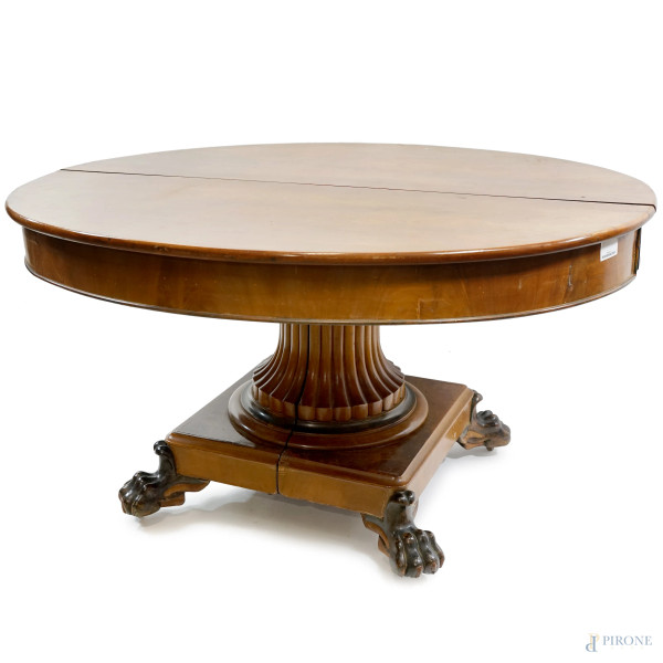 Tavolo in noce del XIX secolo, con piano ovale allungabile, piedistallo centrale con zampe di leone intagliate ed ebanizzate, misure del tavolo chiuso cm h 74x126x104, (difetti)