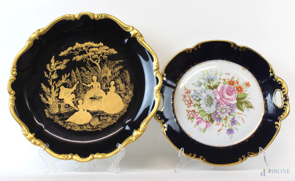 Lotto di due piatti diversi in porcellana policroma raffiguranti scena campestre e bouquet di fiori, diametro max cm 33