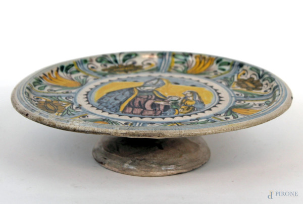 Antica alzata in ceramica policroma, decori a motivi floreali e riserva centrale con scena sacra, cm h 5,5x21,5, (lievi difetti).