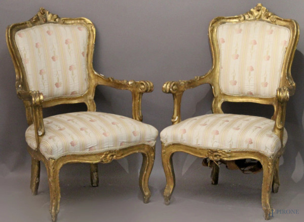 Coppia di poltrone in legno intagliato e dorato con seduta e dorsale in stoffa fiorata. XIX° sec.
