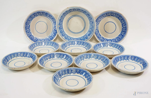 Lotto composto da 8 piatti e 3 centrotavola in ceramica maiolicata bianco/blu, manifattura dell'Italia Meridionale, XIX secolo, diametro max cm 35 circa, (difetti)