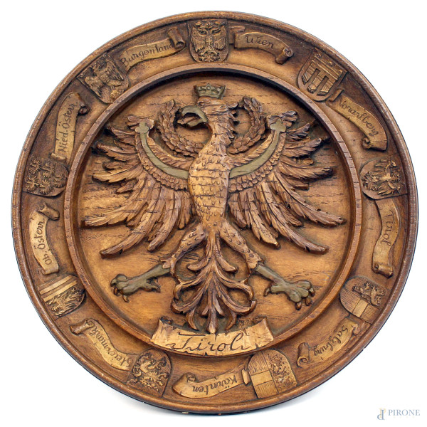 Medaglione in legno intagliato raffigurante aquila imperiale e vari stemmi delle regioni dell'Austria, diam. cm 22, XX secolo, (segni del tempo).
