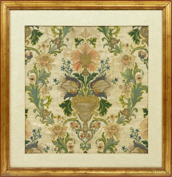 Ricamo su seta in fili colorati, filo d’oro e filo d’argento raffigurante un vaso di fiori tra motivi fogliati, XIX secolo, cm 49x47, entro cornice (difetti)