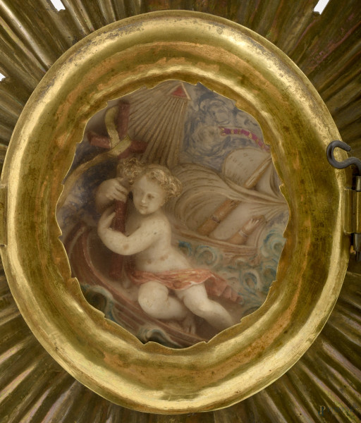 Reliquiario a raggiera con bassorilievo in stucco, XIX scolo, cm 39x27x15, (difetti).