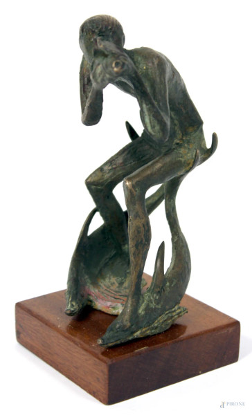 Suonatore di conchiglia cavalcante delfini, scultura in bronzo poggiante su base in legno siglata E.M., H 16 cm.