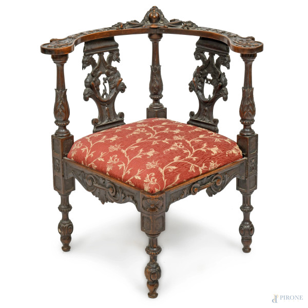 Poltroncina ad angolo con struttura in legno intagliato con seduta rivestita in tessuto nei toni del rosso e dell'oro a motivi floreali,  XIX-XX secolo, cm 79x70x70, (segni di usura, difetti, scalfiture, fori di tarlo)