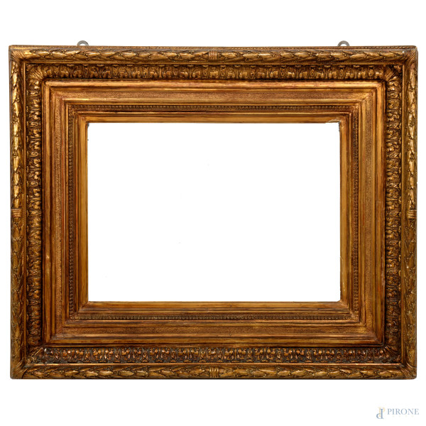 Cornice in legno dorato ed intagliato a volute ed elementi fitmorfi a più ordini di intaglio, XX secolo, cm 100x81 ; battente cm 62x44, (difetti)
