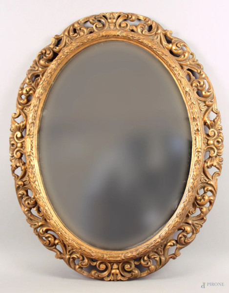 Specchio di linea ovale in pastiglia dorata, met&#224; XX secolo, cm. 63x78.