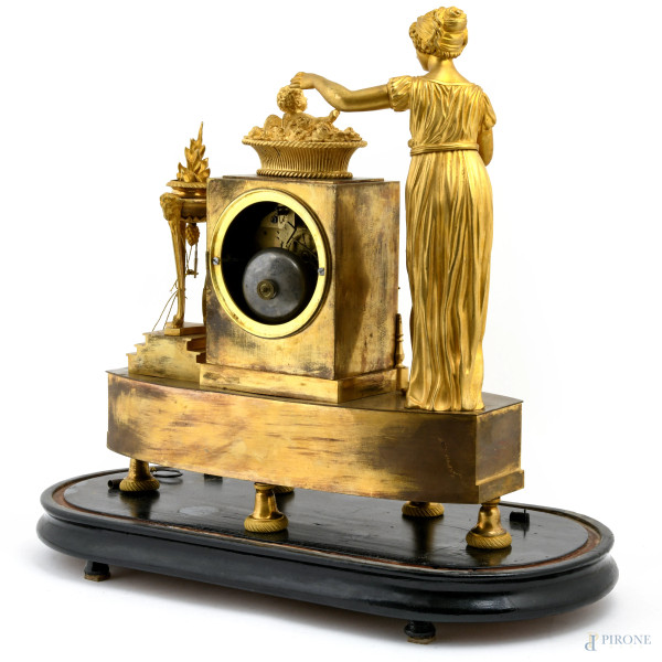 Orologio in bronzo dorato con fanciulla ed amorino. Quadrante a smalto in numeri romani. Entro ca...