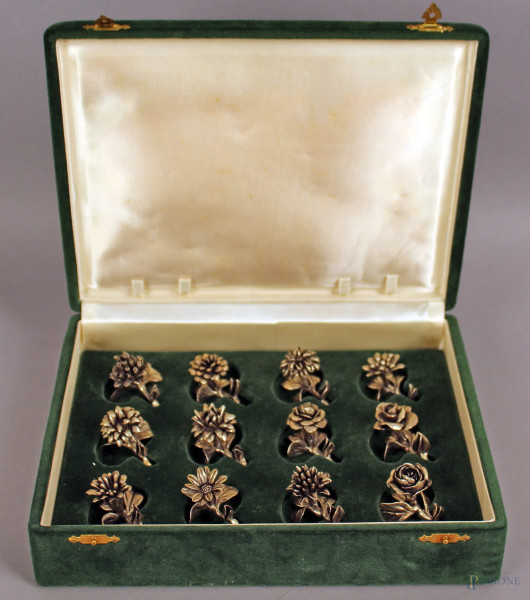 Lotto composto da dodici segnaposti in argento a forma di fiori, lunghezza max. 4 cm, gr. 230.