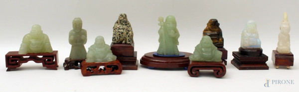 Lotto composto da nove Budda diversi in pietre dure, poggianti su basi in tek, H massima 7 cm.