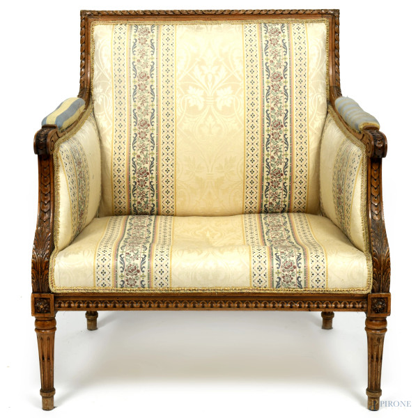 Poltrona stile Luigi XVI secolo in legno intagliato con braccioli, schienale e seduta imbottiti e rivestiti con stoffa ocra a decori floreali nei toni del verde e del turchese, XX secolo, cm 87x79x65 circa, (segni di usura, fori di tarlo, difetti, scalfit