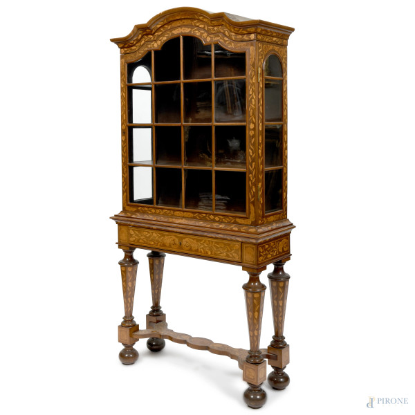 Vetrina in legno con intarsi in varie essenze a motivi vegetali e floreali. Anta vetrata celante vano scandito in quattro ripiani sormontante cassetto. Gambe tornite raccordate da pedana sagomata, XIX-XX secolo, cm 187x89x32, (segni di usura, difetti)