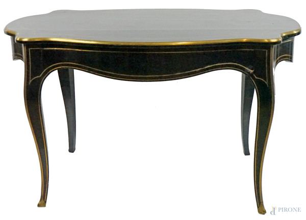 Tavolo scrittoio stile Napoleone III, fine XIX secolo, in legno ebanizzato con filettature in metallo dorato, piano di linea sagomata, un cassetto sottopiano, quattro gambe mosse, cm h 77x125x77, (difetti).