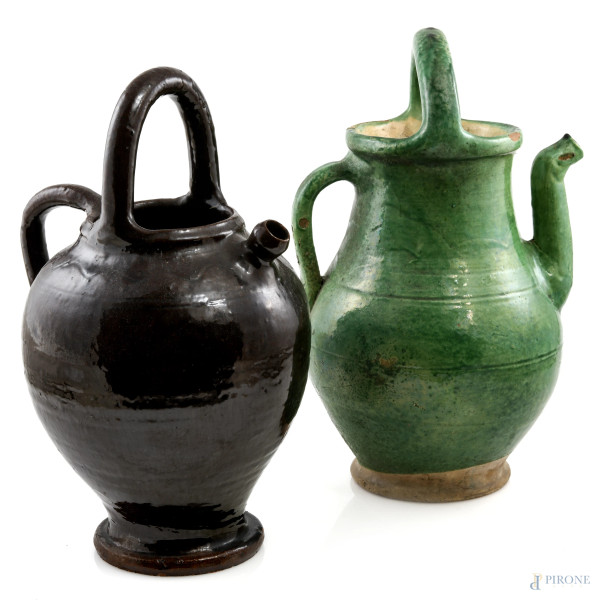 Lotto di due versatoi in maiolica smaltata nei toni del verde e del marrone, XX secolo, misure massime cm 35,5, (segni di usura, cadute di smalto, sbeccature, difetti) 