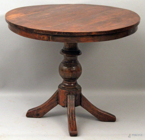 Tavolino di linea tonda in legno a noce, poggiante su colonna e quattro piedi, h. 72x90 cm