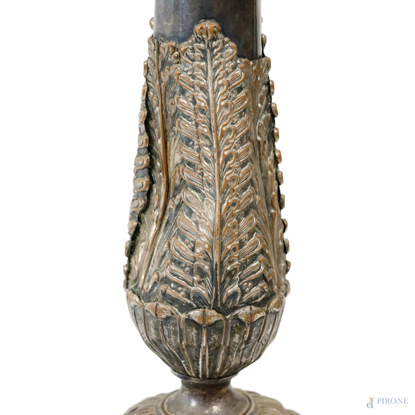 Coppia di candelieri da terra in metallo argentato adattati a lampada, decori cesellati a foggia ...