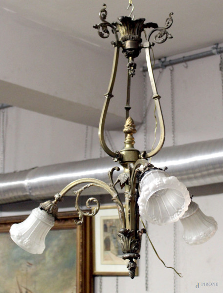 Lampadario in bronzo sbalzato a tre luci, braccia sinuose, cm h 80