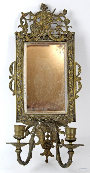 Applique in metallo dorato a due luci con specchiera sormontata dall'allegoria della giustizia, altezza cm. 41x19x12,5, (segni del tempo).
