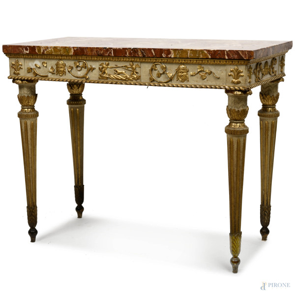 Consolle Luigi XVI in legno laccato e dorato e intagliato con putti, motivi vegetali e teste. Piano  [..]